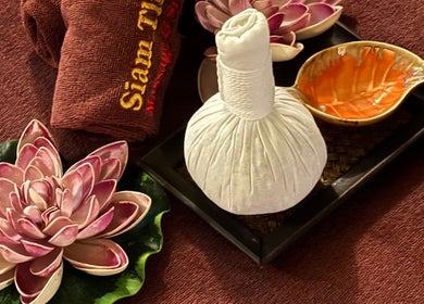 Herbal compress and lotus decor at Siam Thai Massage & Spa, HK, HK, offering a serene wellness ambiance.