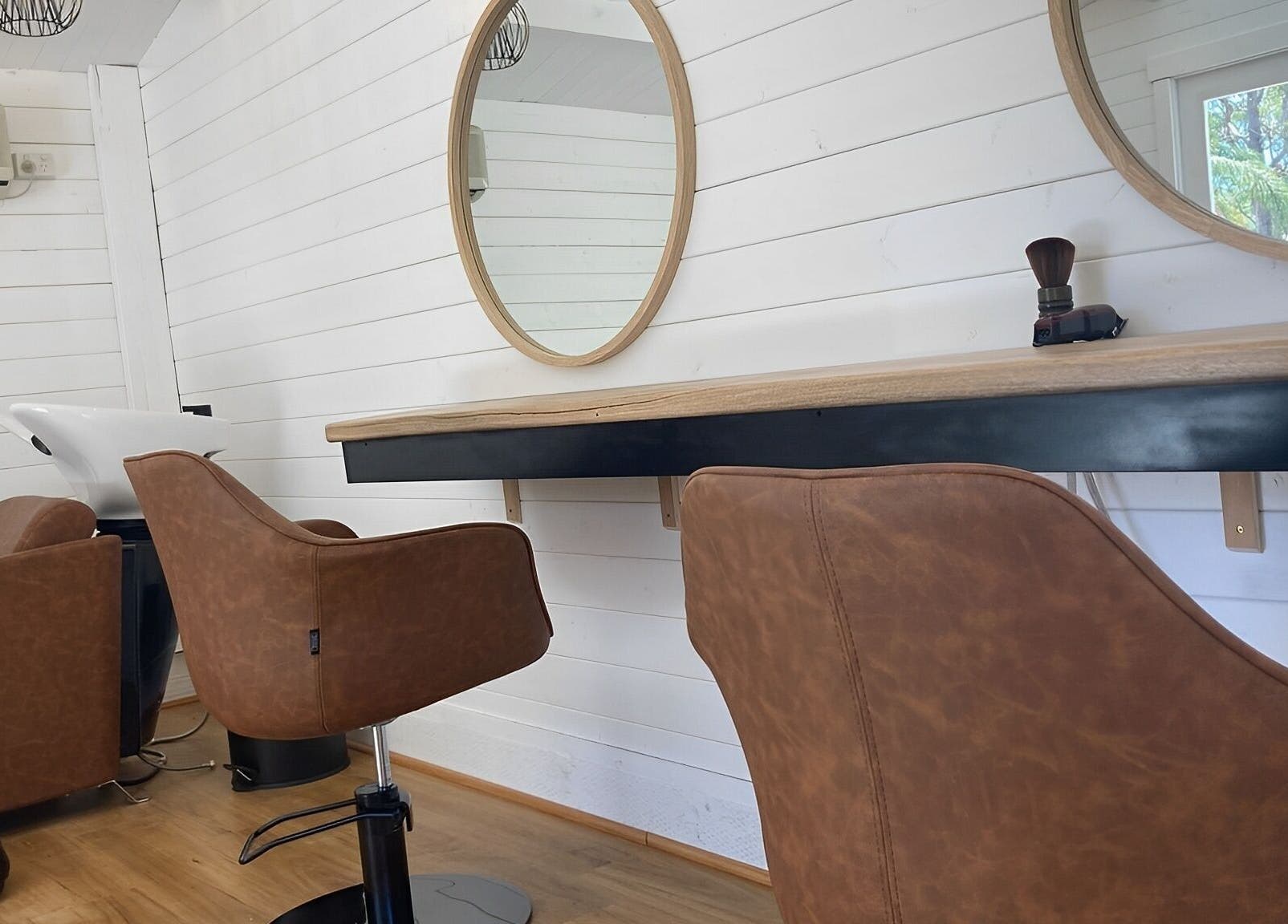 Modern salon interior at Smiths Lake Hair Studio, Smiths Lake, New South Wales, AU with stylish chairs and mirrors.
