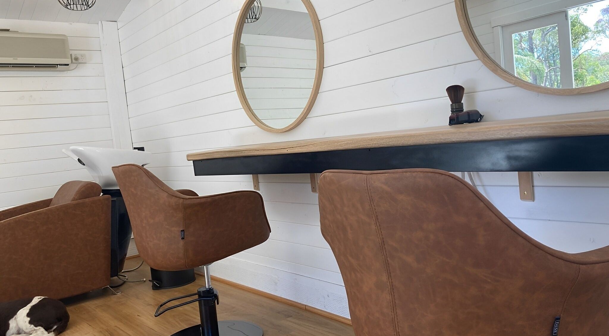 Modern salon interior at Smiths Lake Hair Studio, Smiths Lake, New South Wales, AU with stylish chairs and mirrors.