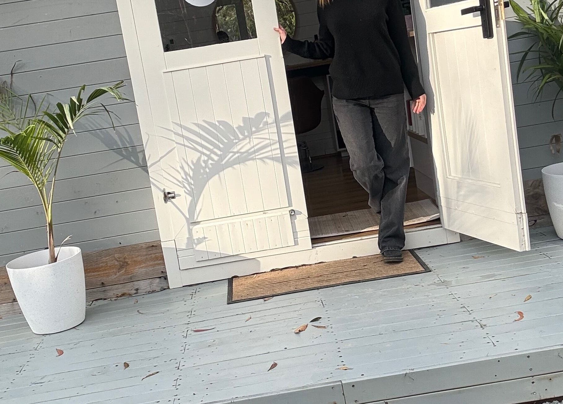 Entrance of Smiths Lake Hair Studio in Smiths Lake, New South Wales, AU, with plants and an open door.