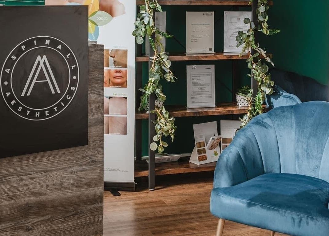Cozy waiting area at Aspinall Aesthetics, Kingswood, England, GB featuring a plush blue chair and greenery.