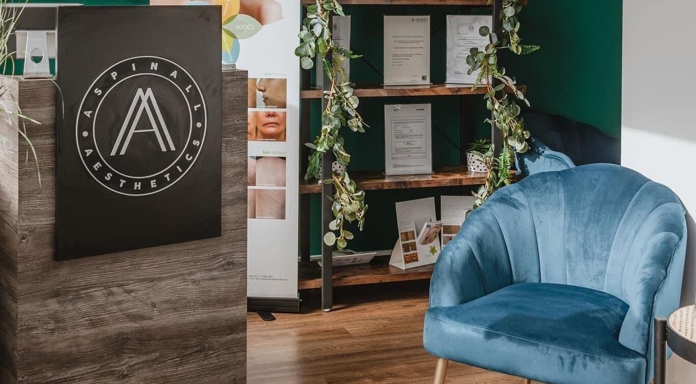 Cozy waiting area at Aspinall Aesthetics, Kingswood, England, GB featuring a plush blue chair and greenery.