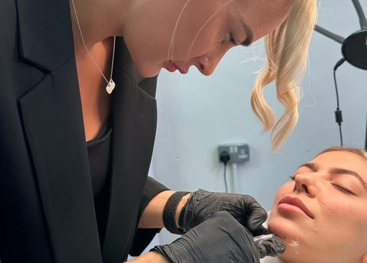 Skilled professional at Aspinall Aesthetics, Kingswood, England, GB, delivering a facial treatment with precision.