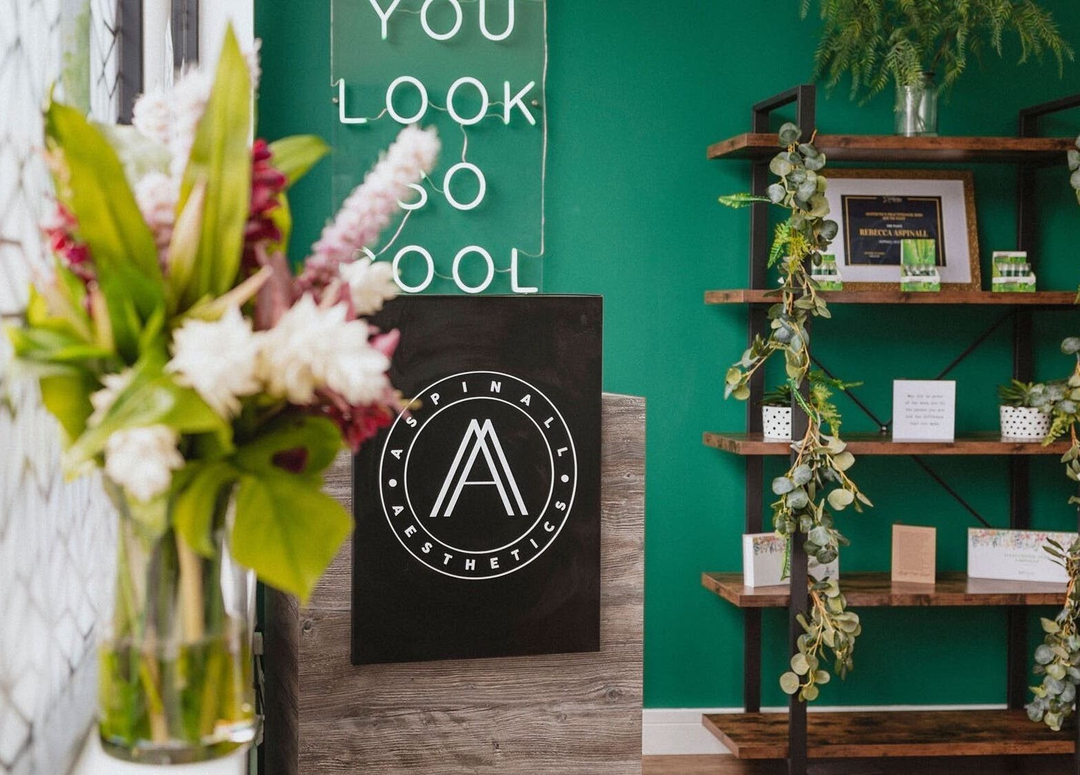 Aspinall Aesthetics reception with green walls and modern decor in Kingswood, England, GB.