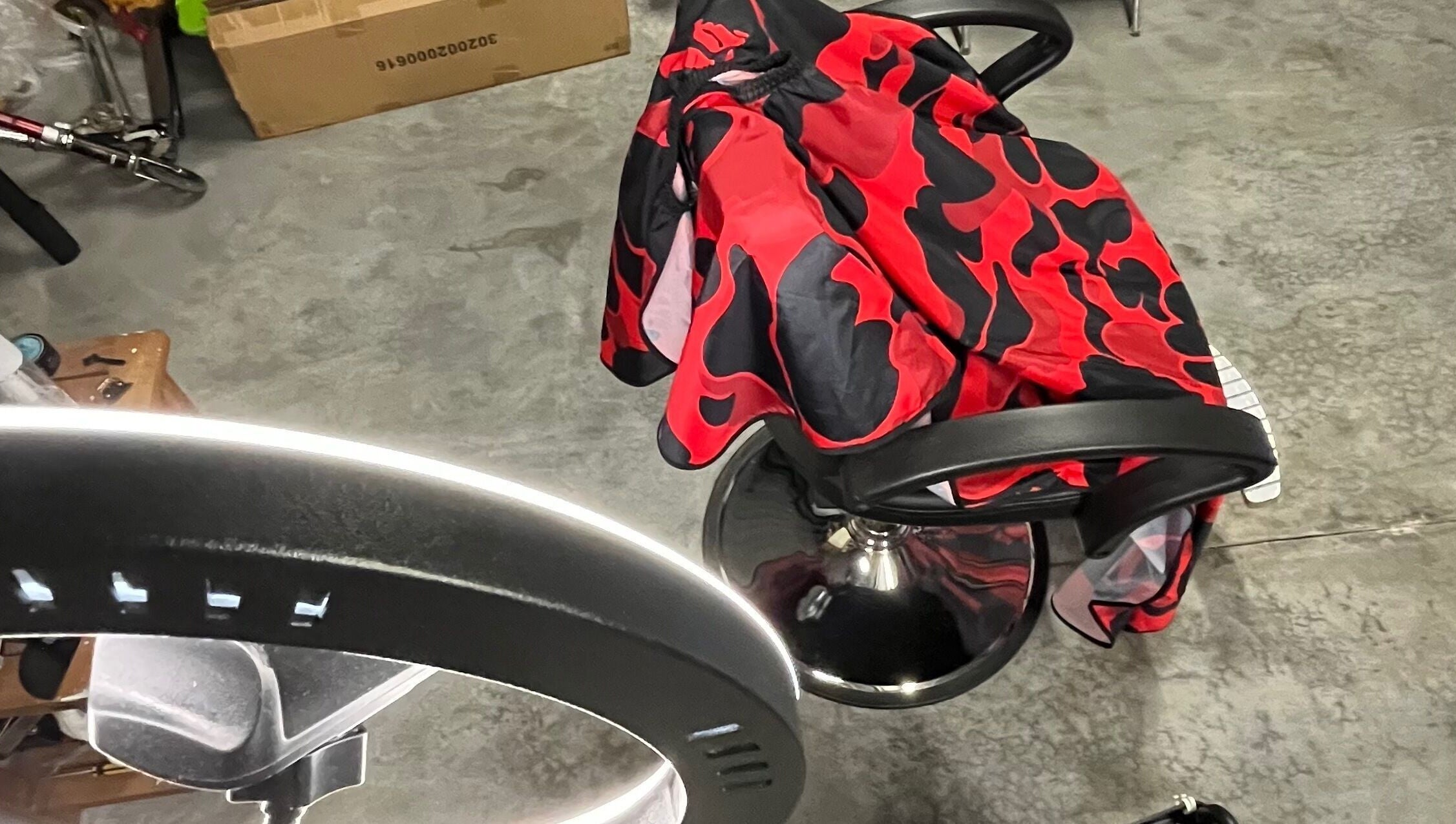 Espace moderne chez Tms Cutz à Zaventem, Vlaams Gewest, BE, avec chaise de coiffure et cape rouge à motifs.