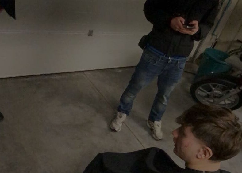 Jeune homme chez Tms Cutz, Zaventem, Vlaams Gewest, BE, prêt pour une coupe de cheveux dans un espace de garage.