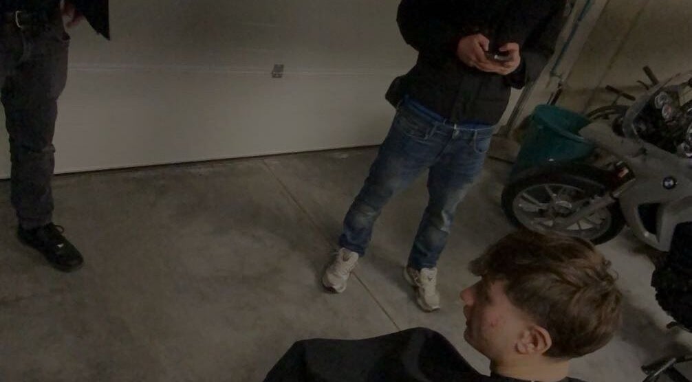 Jeune homme chez Tms Cutz, Zaventem, Vlaams Gewest, BE, prêt pour une coupe de cheveux dans un espace de garage.