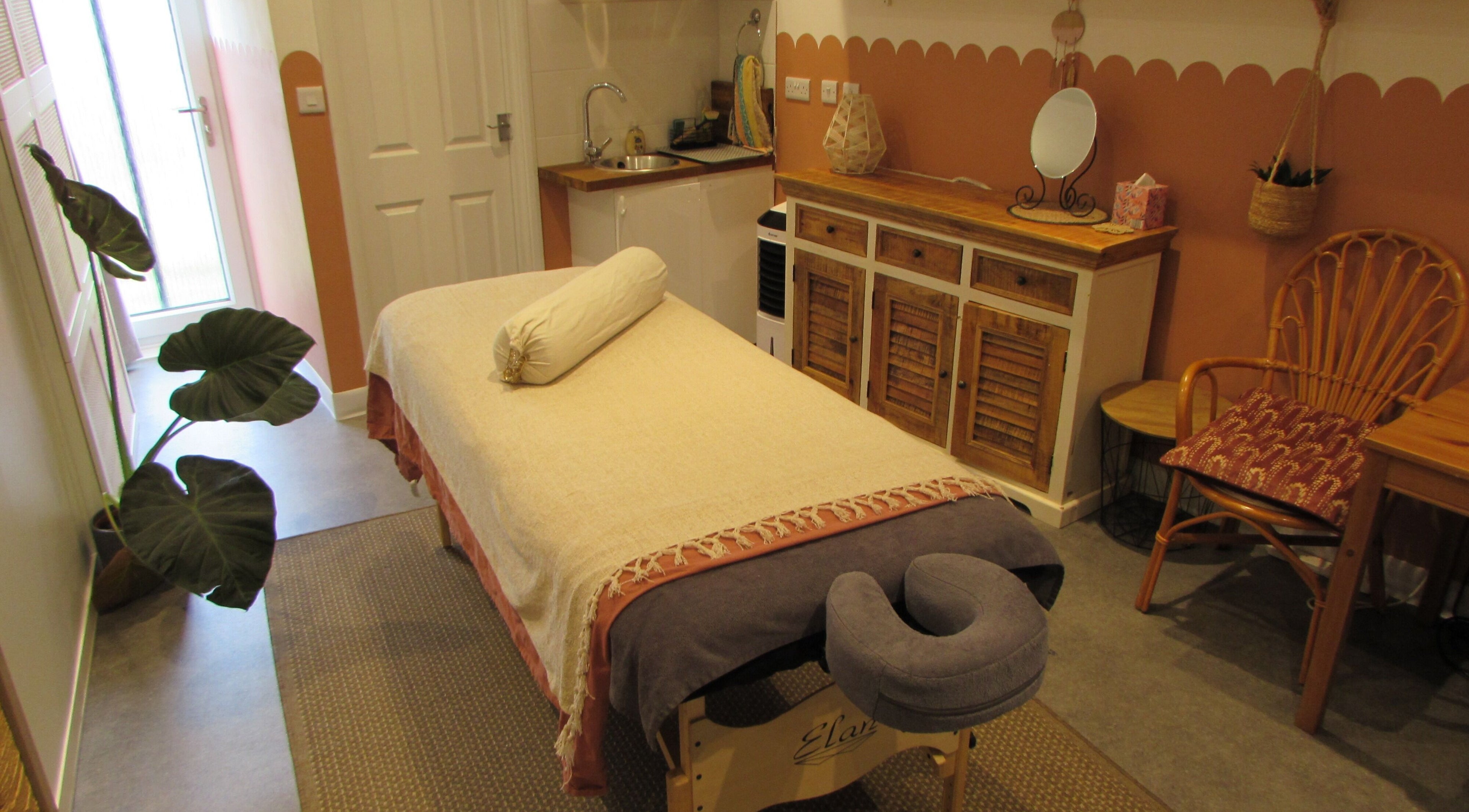 Calm therapy room at Laura Jane Holistic in Bristol, England, GB with massage table and warm decor.