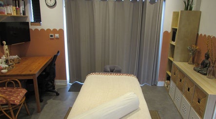 Relaxing treatment room at Laura Jane Holistic, Bristol, England, GB, featuring a cozy massage table and warm decor.
