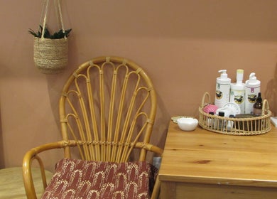 Cozy wellness corner at Laura Jane Holistic, Bristol, England, GB, featuring a wicker chair and products.