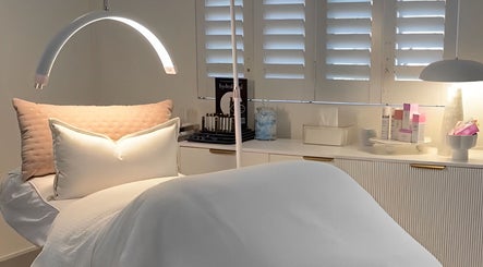 Serene treatment room at The Dermal Collection in Cape Town, Western Cape, ZA with cozy bedding and products.