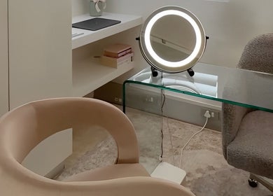 Elegant beauty station at The Dermal Collection, Cape Town, Western Cape, ZA, featuring a round mirror and plush chairs.