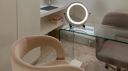 Elegant beauty station at The Dermal Collection, Cape Town, Western Cape, ZA, featuring a round mirror and plush chairs.