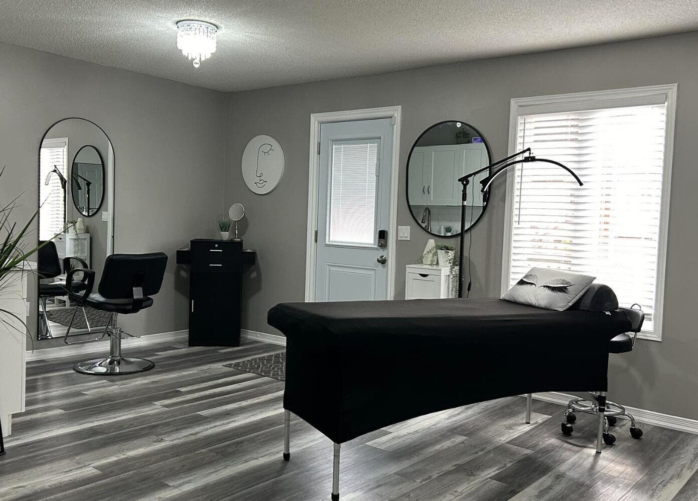 Modern aesthetic room at Endulgence Esthetics, London, Ontario, CA, featuring sleek styling chair and treatment bed.