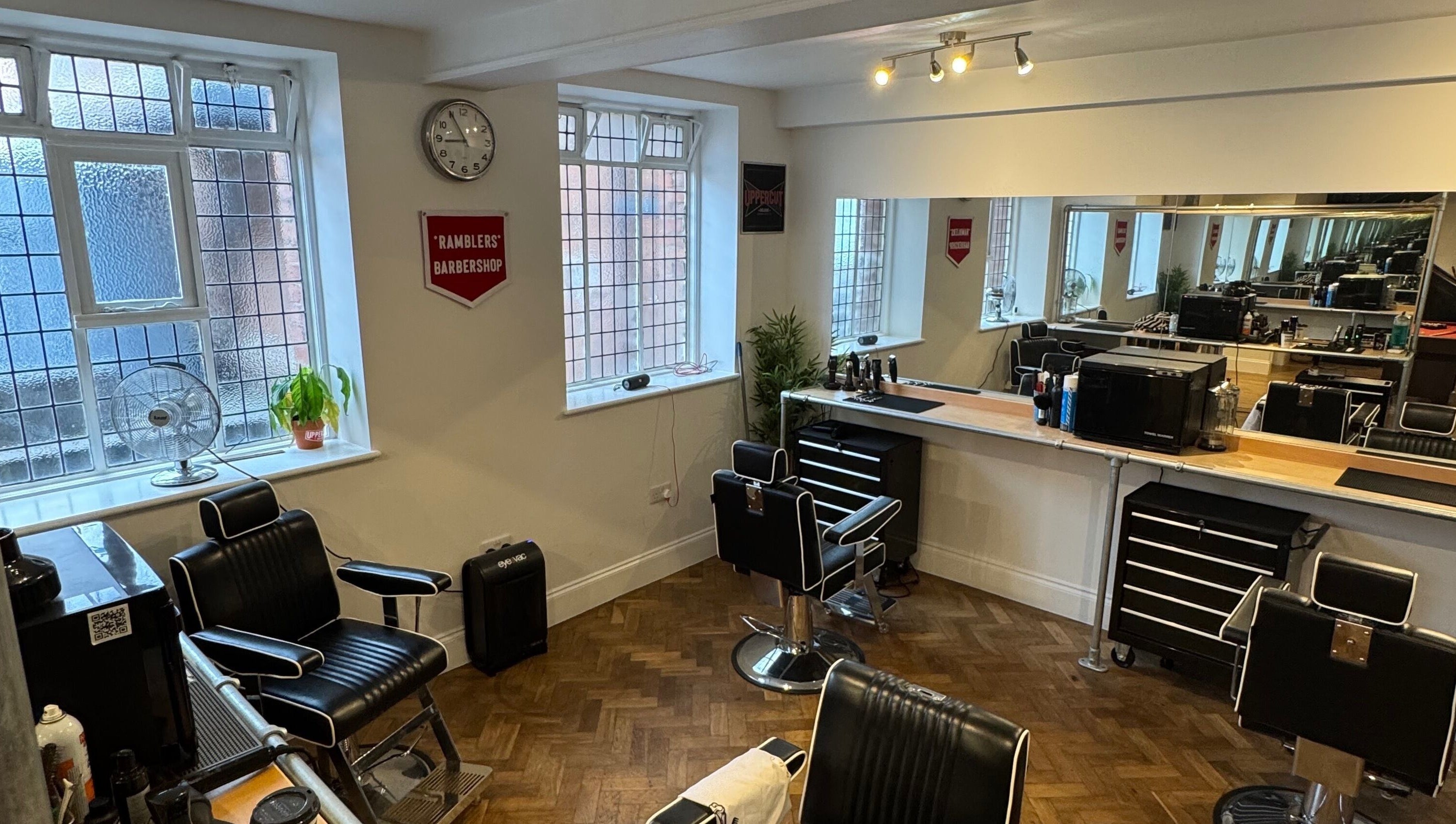 Interior of Ramblers Barbershop in Hereford, England, featuring sleek barber chairs and modern decor.
