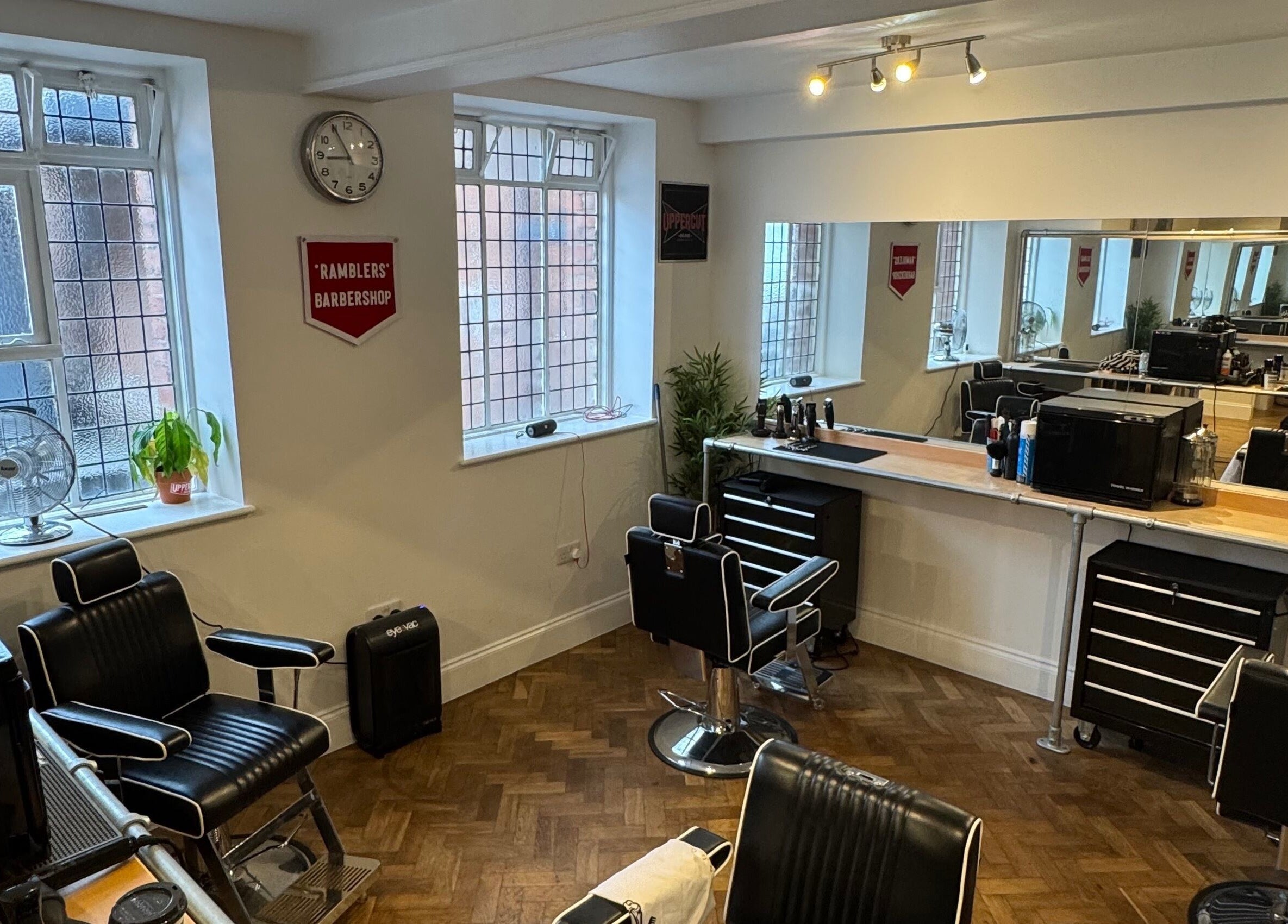 Interior of Ramblers Barbershop in Hereford, England, featuring sleek barber chairs and modern decor.
