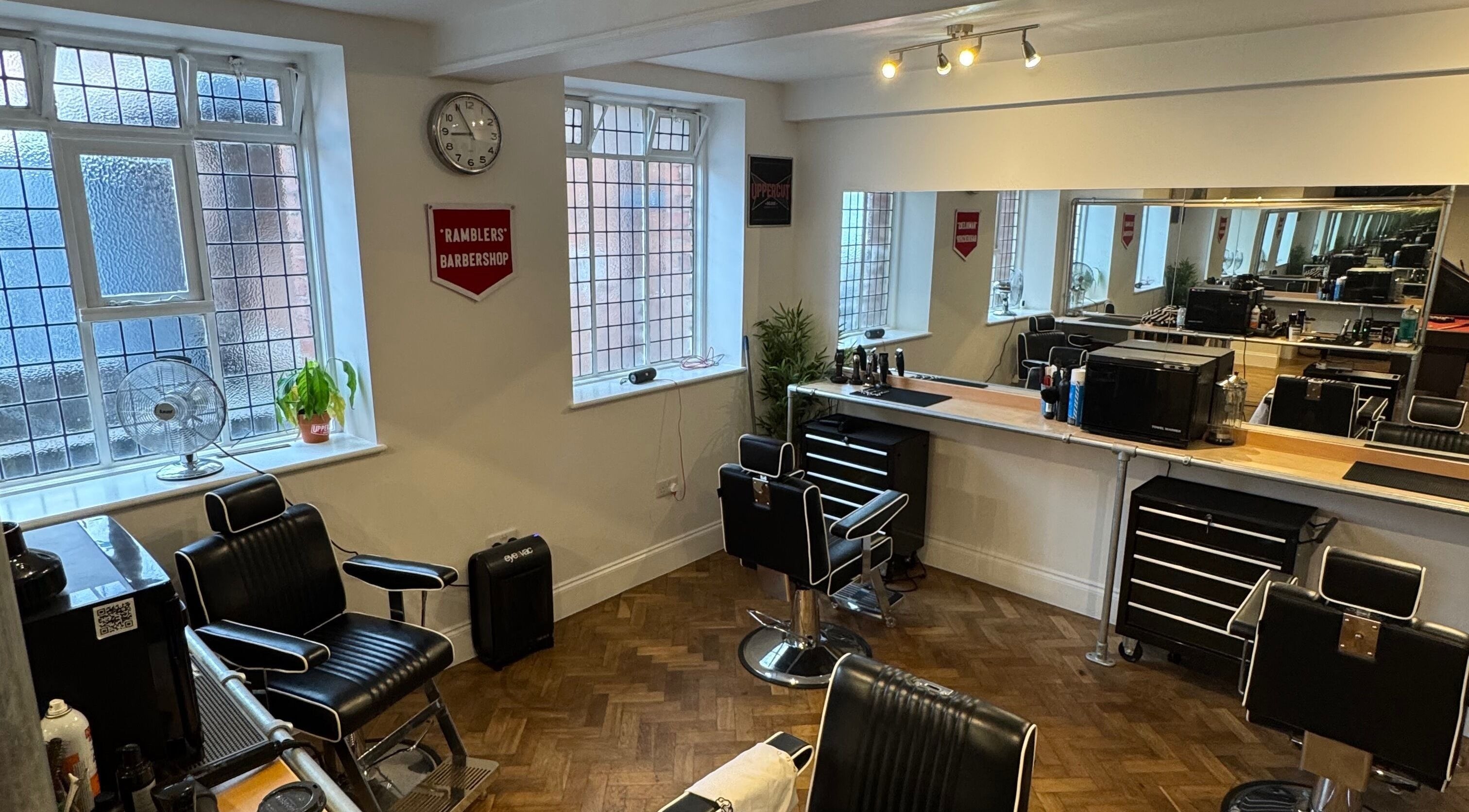 Interior of Ramblers Barbershop in Hereford, England, featuring sleek barber chairs and modern decor.