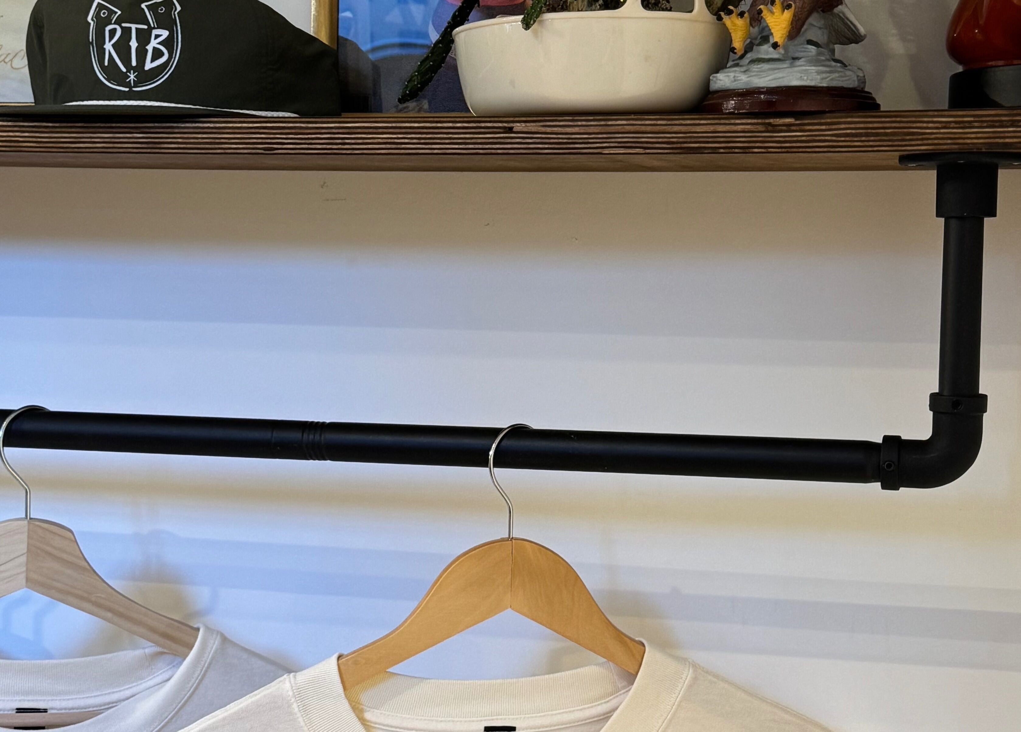 Shelf at Ramblers Barbershop in Hereford, England, featuring branded items and hanging clothing.