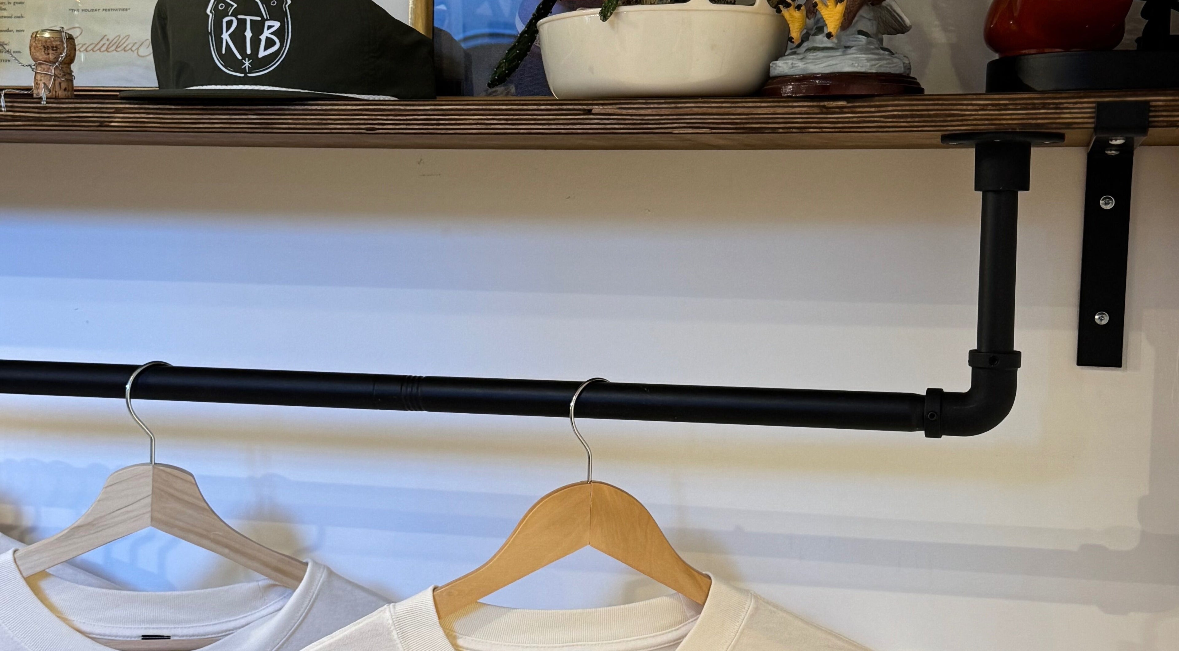 Shelf at Ramblers Barbershop in Hereford, England, featuring branded items and hanging clothing.