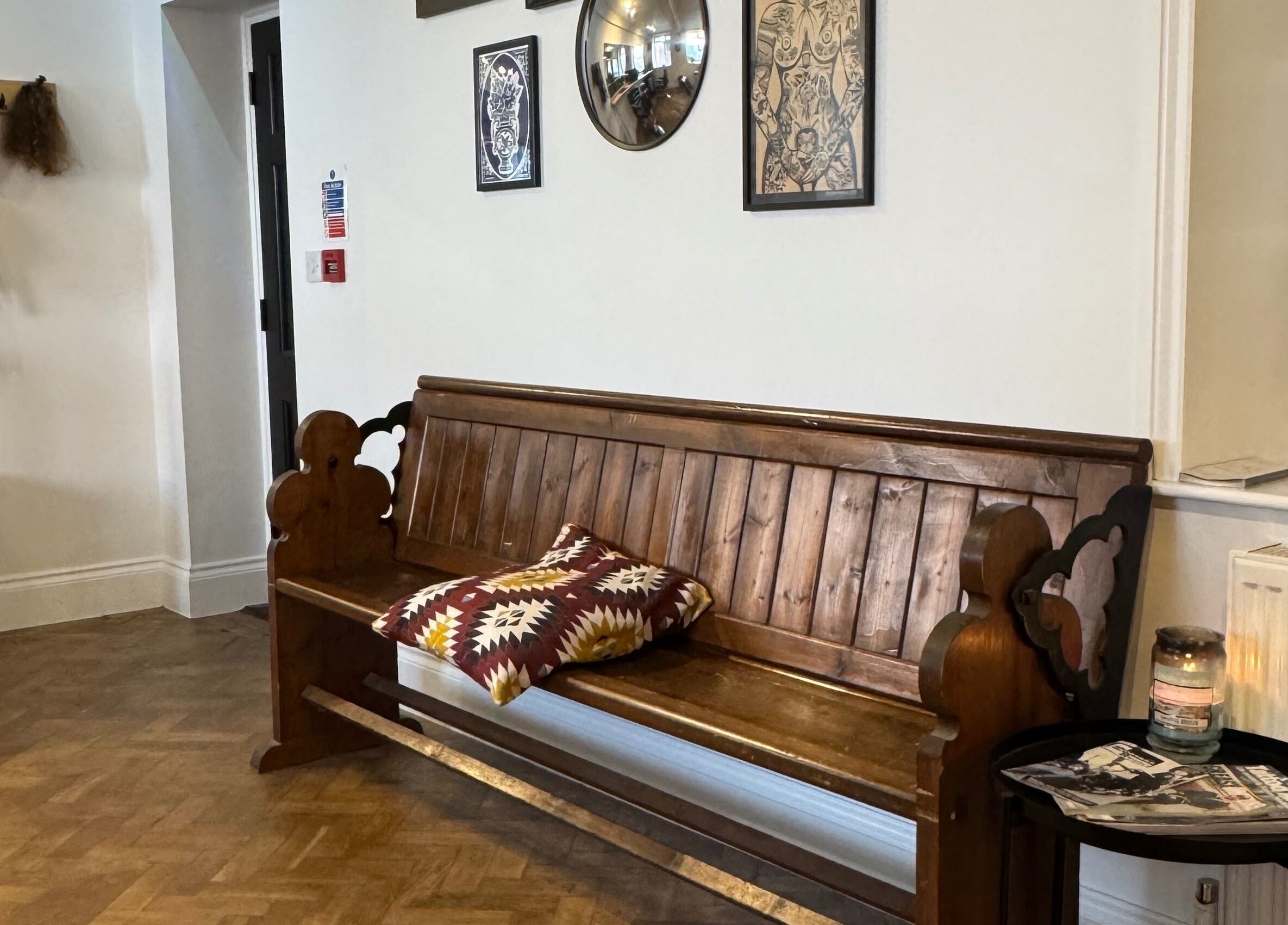 Cozy seating area with wooden bench at Ramblers Barbershop, Hereford, England, GB.