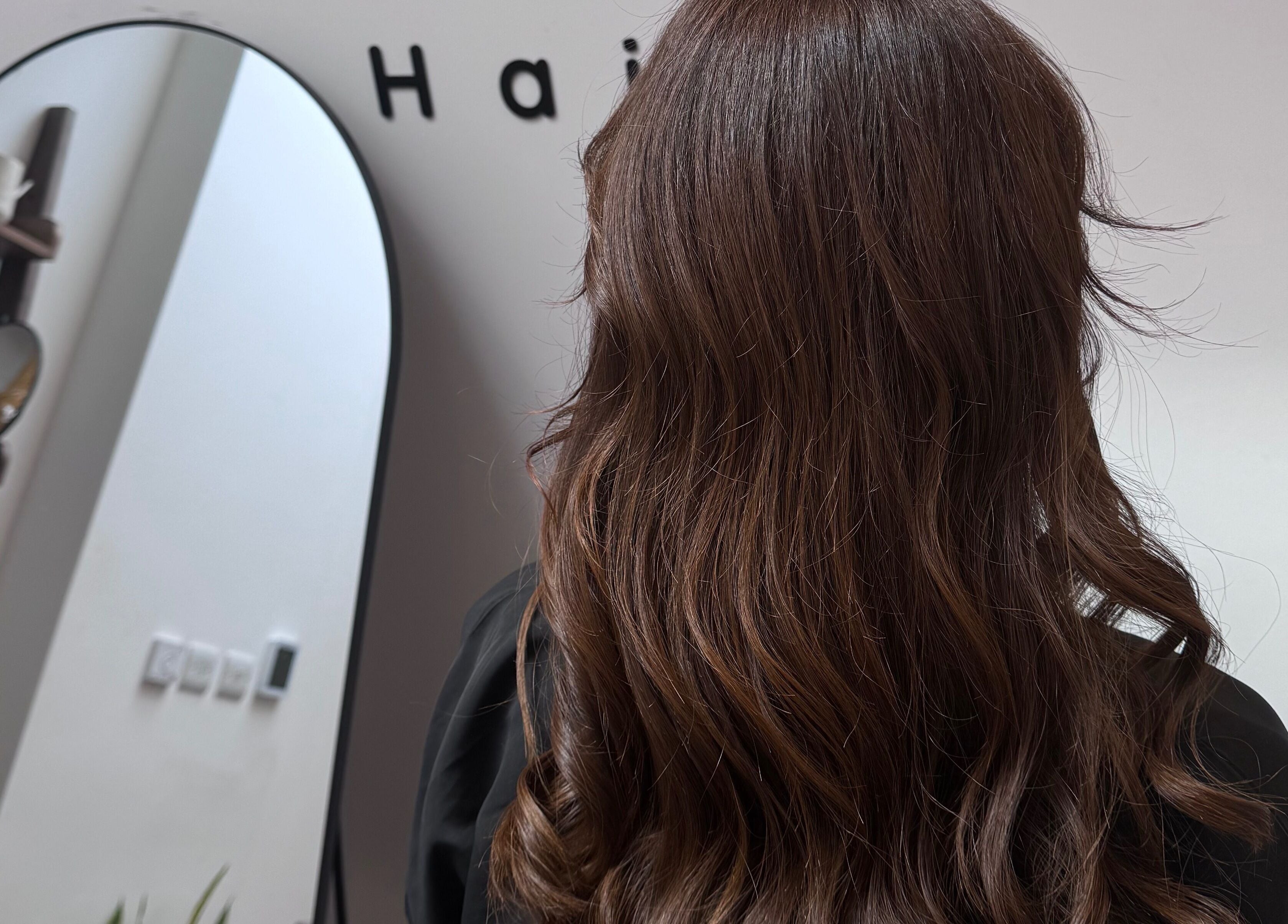 Brunette hair styled at Mocha Hair, South Croydon, England, GB in front of salon mirror.