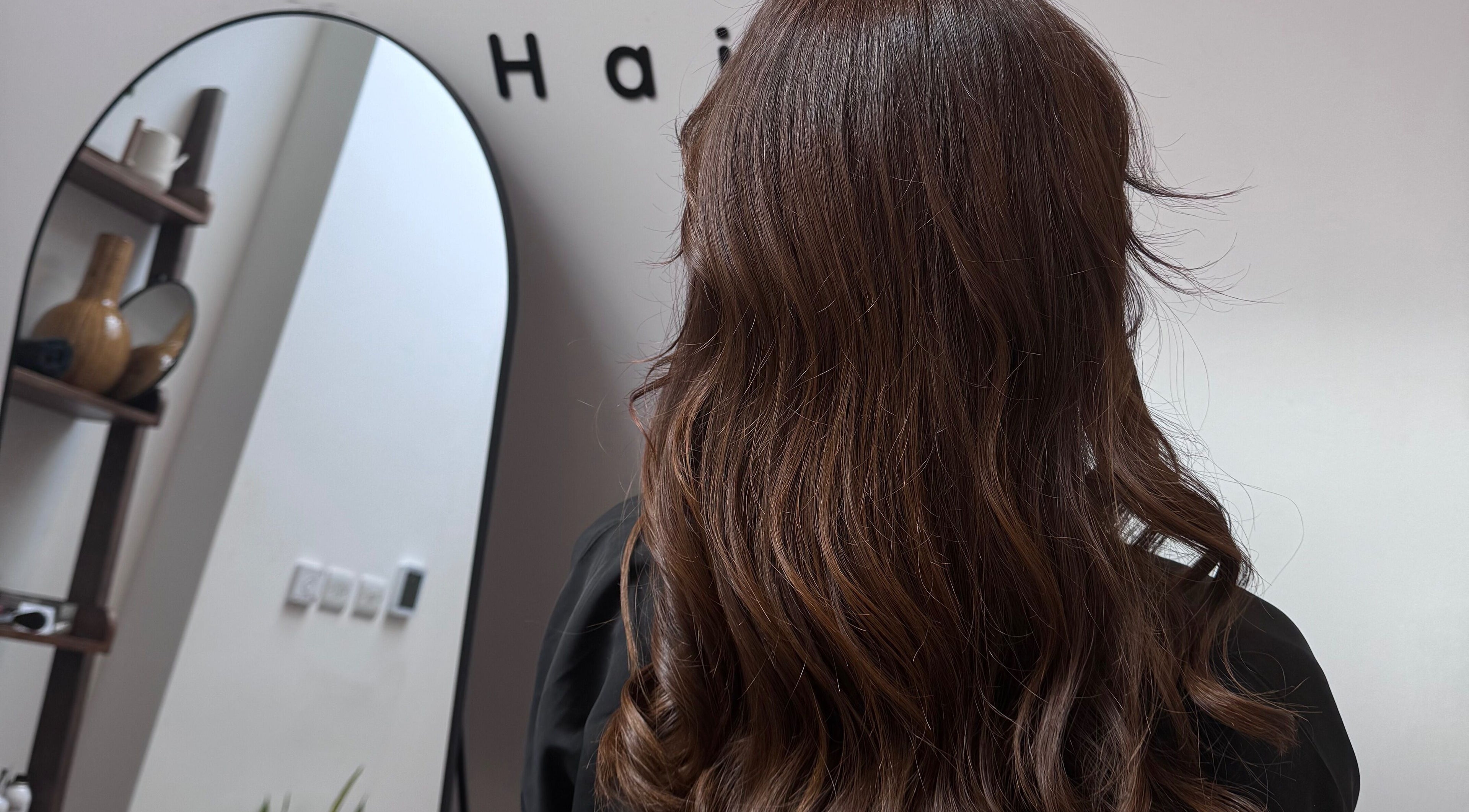Brunette hair styled at Mocha Hair, South Croydon, England, GB in front of salon mirror.
