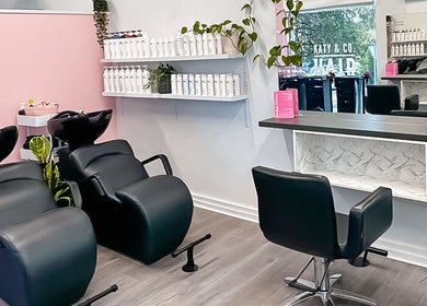 Modern salon interior at Katy & Co. Hair in Engadine, New South Wales, AU with stylish chairs and shelves.