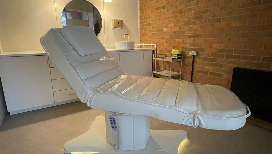 Luxurious treatment bed in serene NL Aesthetics, Worcester, England, GB, showcasing modern amenities.