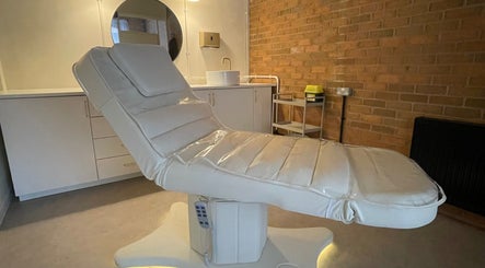 Luxurious treatment bed in serene NL Aesthetics, Worcester, England, GB, showcasing modern amenities.