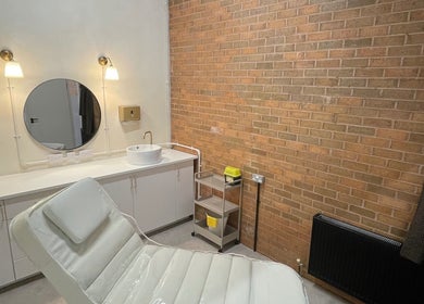 Contemporary treatment room at NL Aesthetics, Worcester, England, GB with a white chair and modern decor.