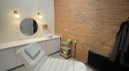 Contemporary treatment room at NL Aesthetics, Worcester, England, GB with a white chair and modern decor.