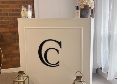 Reception area at NL Aesthetics, Worcester, England, GB featuring elegant decor with flowers and candles.