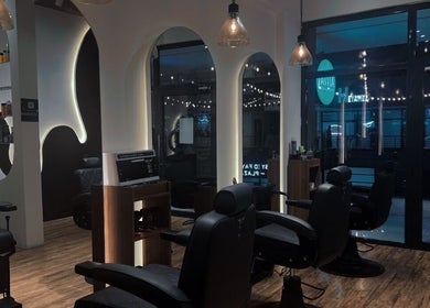 Modern interior of Lasgidi BarberShop, مسقط, Muscat Governorate, OM - stylish grooming chairs and decorations.