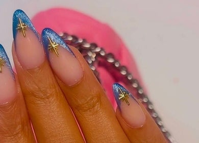 Elegant nail art with blue tips and golden stars at Madelyn Chicago Nail Spa, Chicago, Illinois, US.