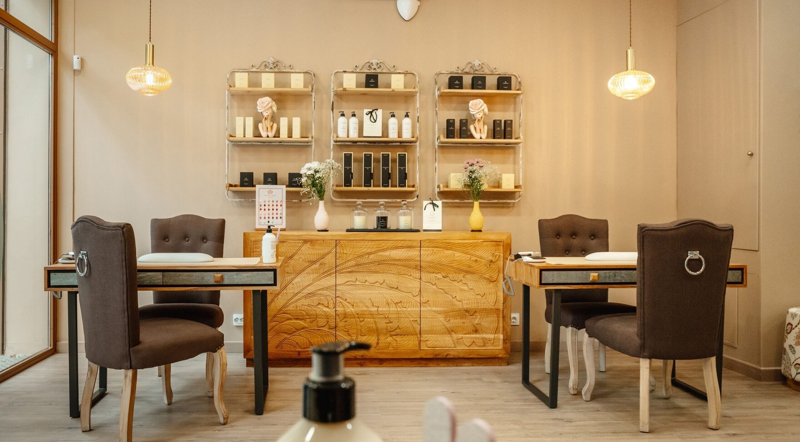 Interior elegante de Bloom Nails & Beauty Boutique en Barcelona, Catalunya, ES, con mesas y sillas modernas.