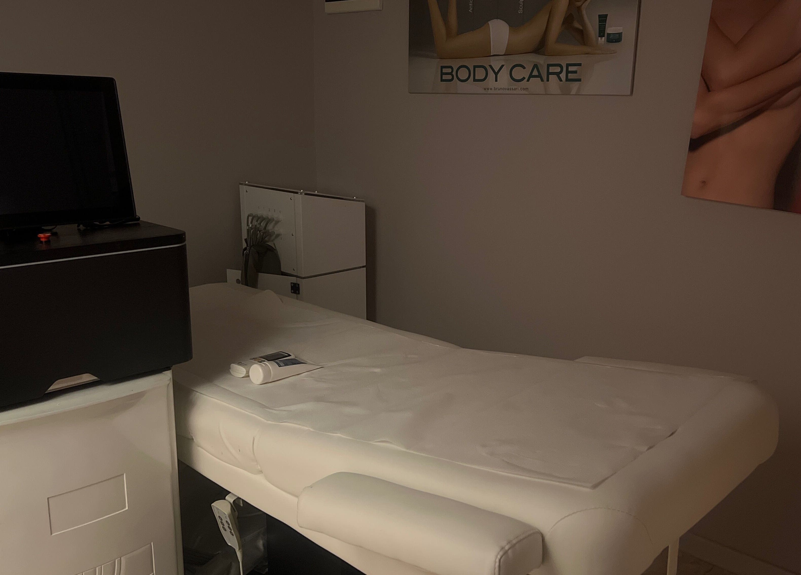 Sala massaggi a Leda Beauty Center, Firenze, Toscana, IT, con lettino bianco e attrezzature moderne.