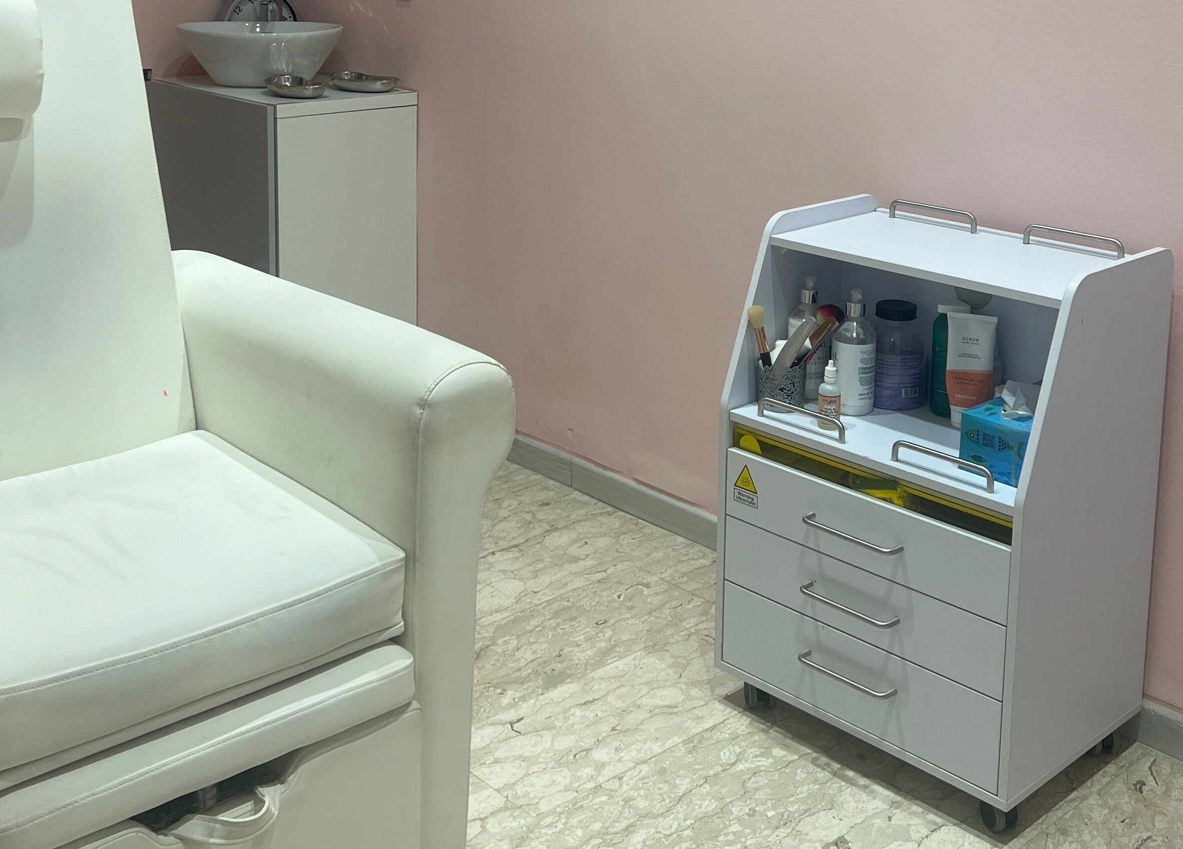 Angolo trattamento presso Leda Beauty Center, Firenze, Toscana, IT, con lettino bianco e mobile attrezzi.