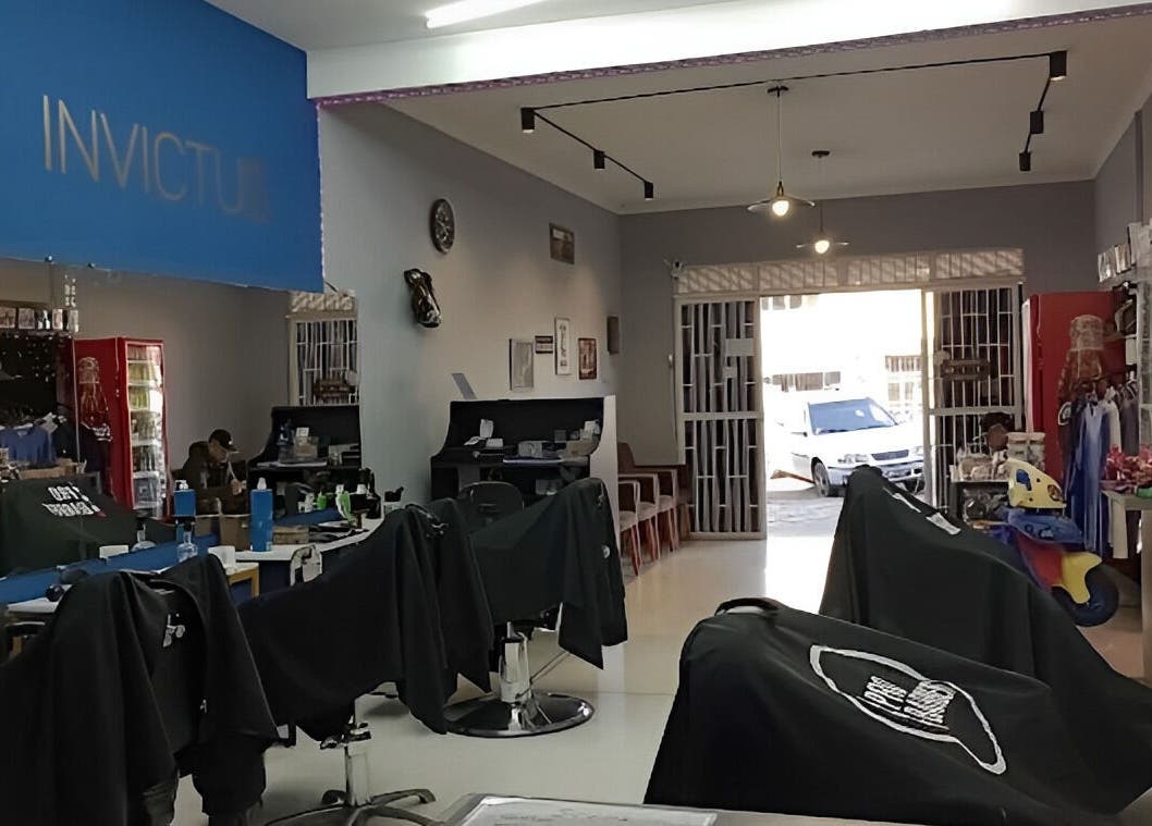 Interior da Barbearia Invictus em Rio Grande Do Sul, BR, com cadeiras de barbearia modernas.