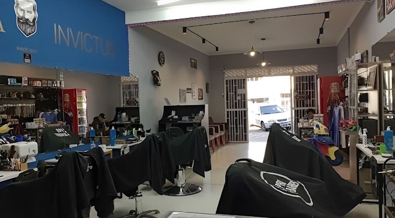 Interior da Barbearia Invictus em Rio Grande Do Sul, BR, com cadeiras de barbearia modernas.