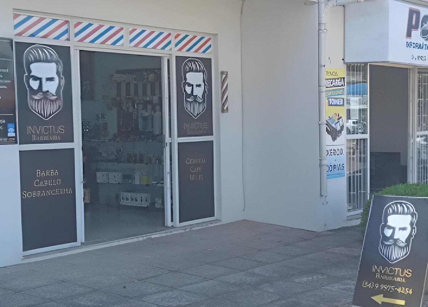 Entrada da Barbearia Invictus em Rio Grande Do Sul, BR, com placa estilizada e fachada moderna.