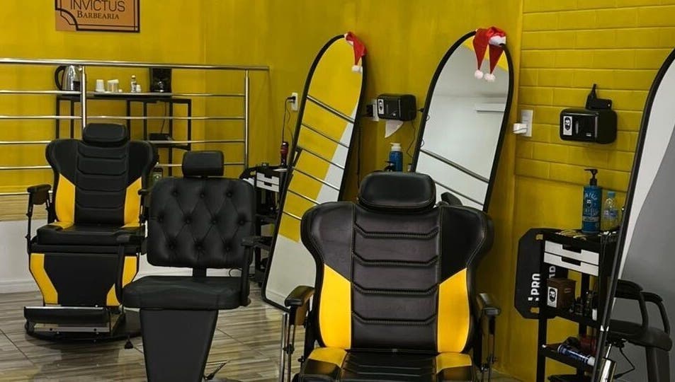 Interior da BARBEARIA INVICTUS EXPRESS em Rio Grande Do Sul, BR, com cadeiras de barbeiro e espelhos modernos.