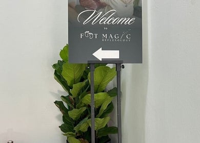 Welcome sign at Foot Magic Reflexology, SERI KEMBANGAN, Selangor, MY beside lush green plant.