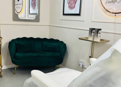 Chic lounge at NZ Aesthetic Cosmetology in Coventry, England, GB. Features stylish decor and a plush green sofa.