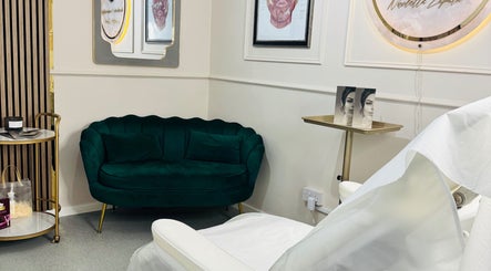 Chic lounge at NZ Aesthetic Cosmetology in Coventry, England, GB. Features stylish decor and a plush green sofa.