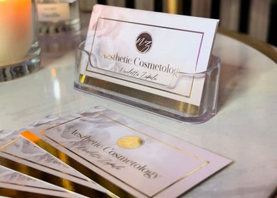 Business cards for NZ Aesthetic Cosmetology, Coventry, England showcased on a sleek holder.