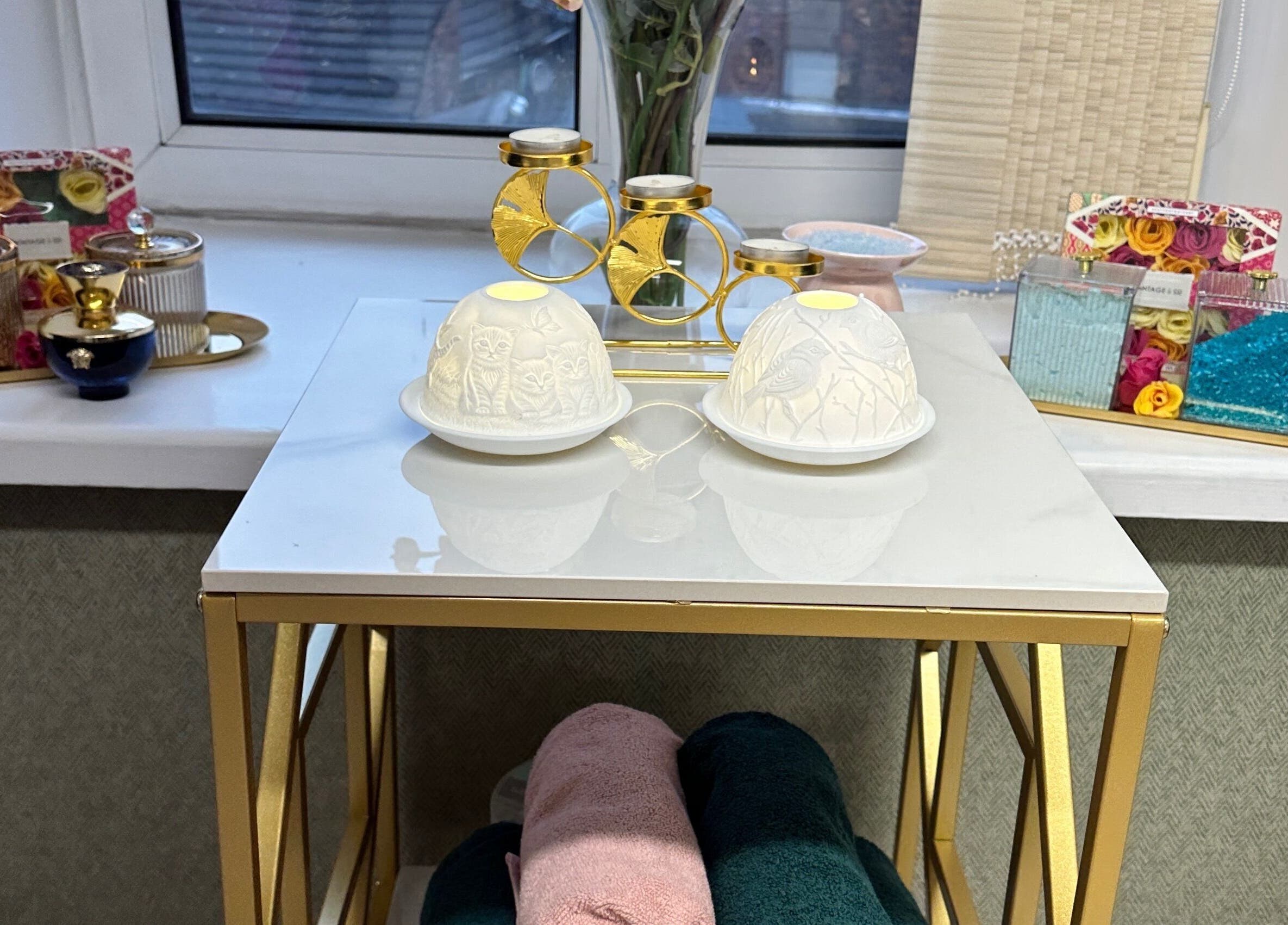 Eleganza Nails in Manchester offers serene decor with gold accents and candles on elegant tables.