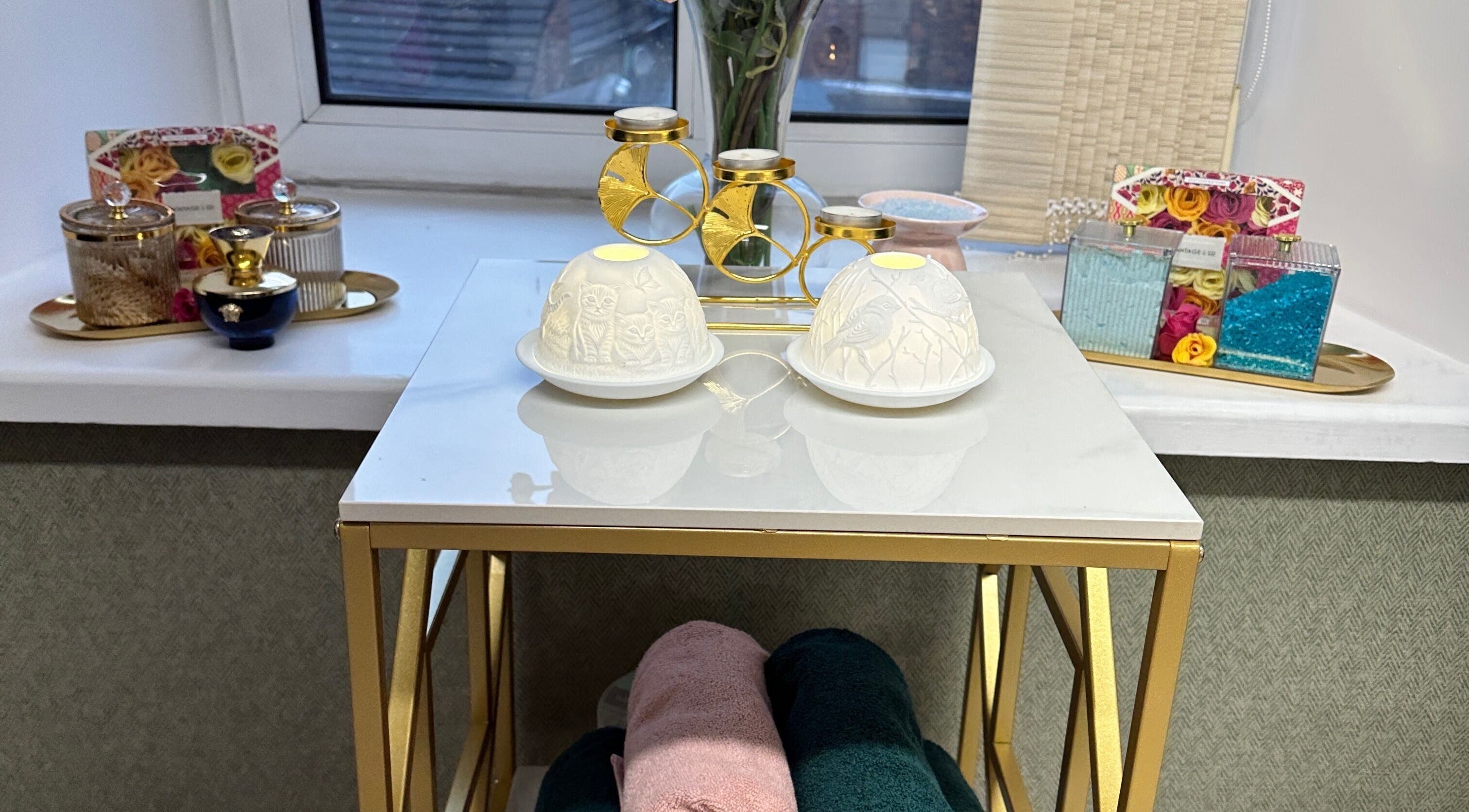 Eleganza Nails in Manchester offers serene decor with gold accents and candles on elegant tables.