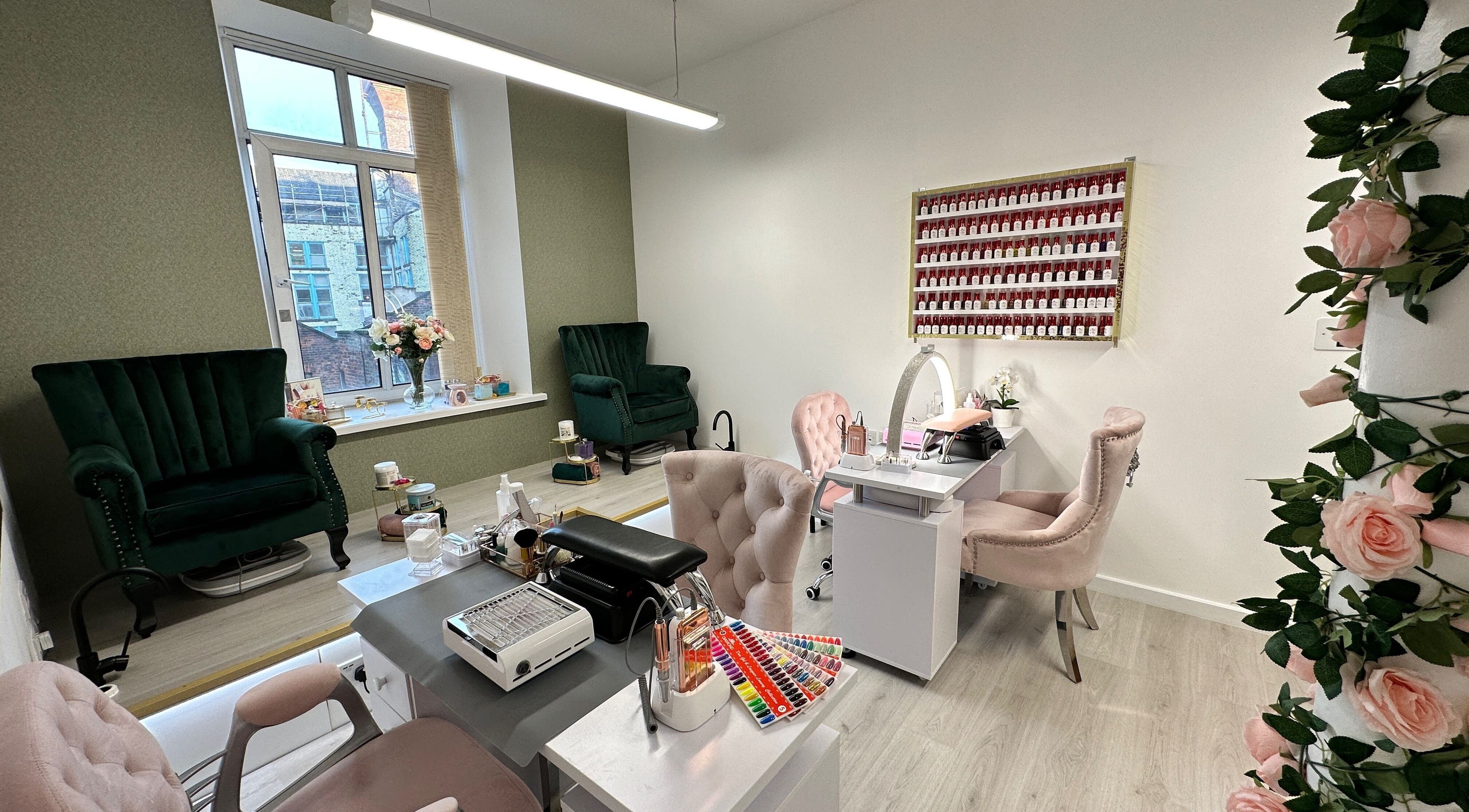 Chic interior of Eleganza Nails in Manchester, England, GB with plush chairs and nail polish display.