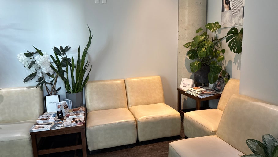 Coin salon chic à Odyssee derme, Brossard, Québec, CA avec plantes et fauteuils crème.