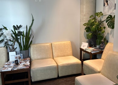 Coin salon chic à Odyssee derme, Brossard, Québec, CA avec plantes et fauteuils crème.